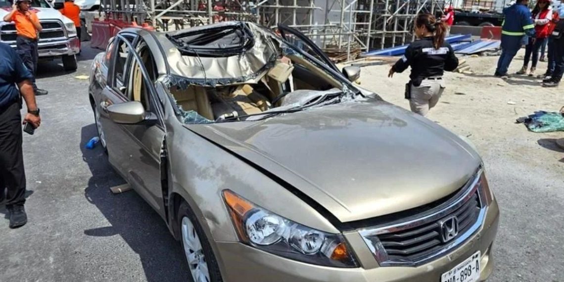 Gold Honda Sedan with Severely Damaged Roof and Shattered Side Windows at an Accident Scene, Construction Scaffolding in the Background. - Salud Regia