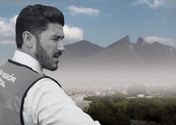 Male worker in a safety vest gazes over a hazy city with mountains in the distance; a red thumbs-down icon signals disapproval or warning.