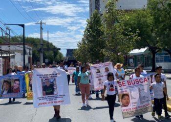 Crowd of Protesters Marching Down a Sunny City Street, Carrying Large Missing-person Posters Labeled 'se Busca' with Photos. - Salud Regia